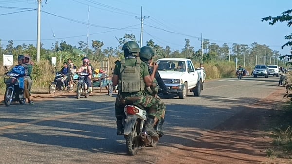 Cambodian soldiers ride their motorbike as local residents evacuate following clashes along the Cambodia-Thailand border