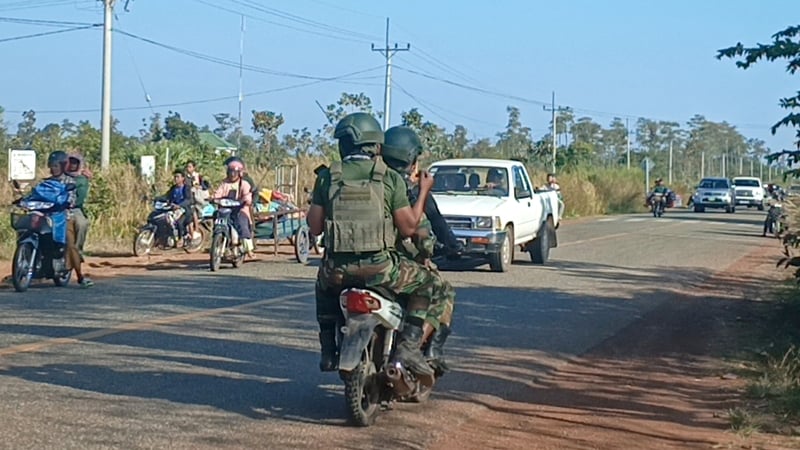 Cambodian soldiers ride their motorbike as local residents evacuate following clashes along the Cambodia-Thailand border