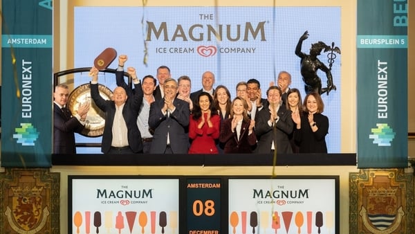 Picture of a group of people cheering with the Magnum and Euronext Amsterdam branding in the background