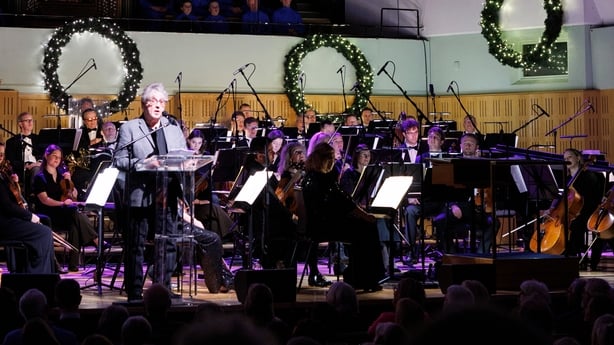 poet Paul Muldoon reads on stage, with the RTÉ Concert Orchestra, at Sunday Miscellany Christmas Concert, National Concert Hall, Dec 2025