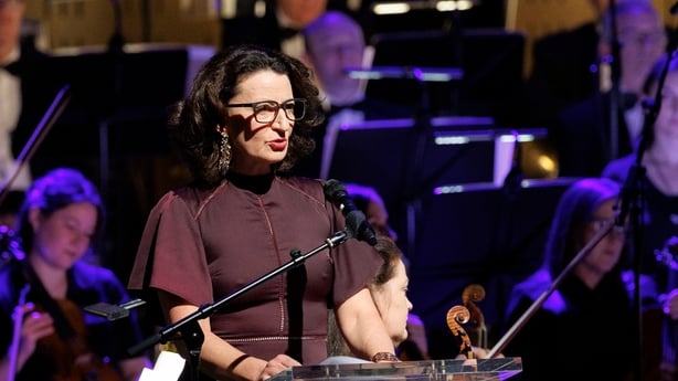 writer Kathleen MacMahon reads on stage, with RTÉ Concert Orchestra in background, at Sunday Miscellany Christmas concert, National Concert Hall, Dec 2025
