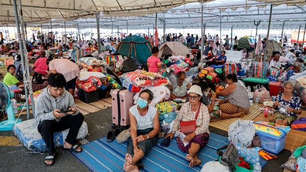 People gather under a temporary shelter
