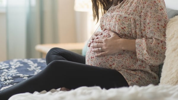 a pregnant woman with her hands on her stomach
