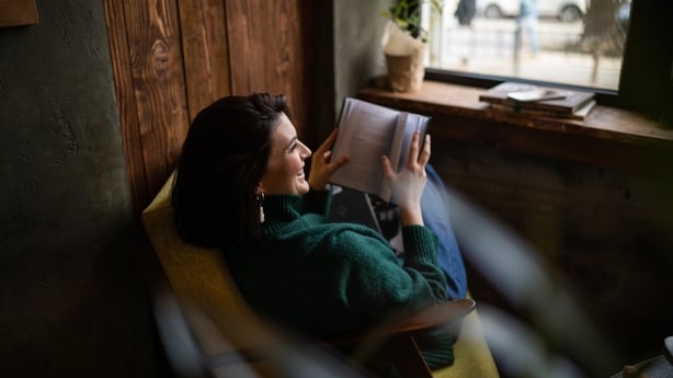 woman sitting in chair and reading a book