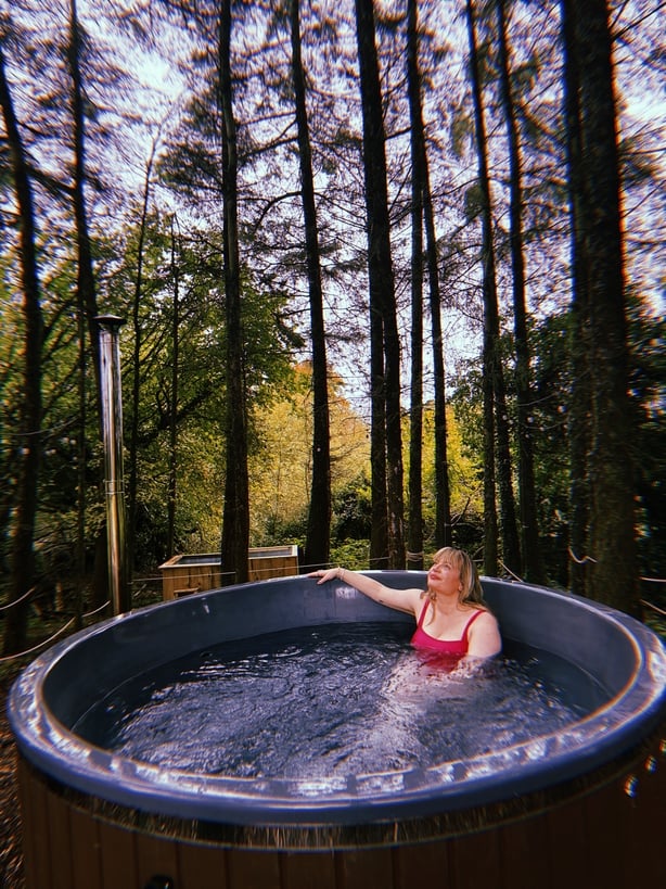 Tara Povey in a forest hot tub at Barrow Sauna Laois landscape