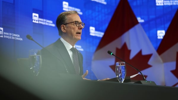 Image of a banker at a table with the Canadian flag behind him