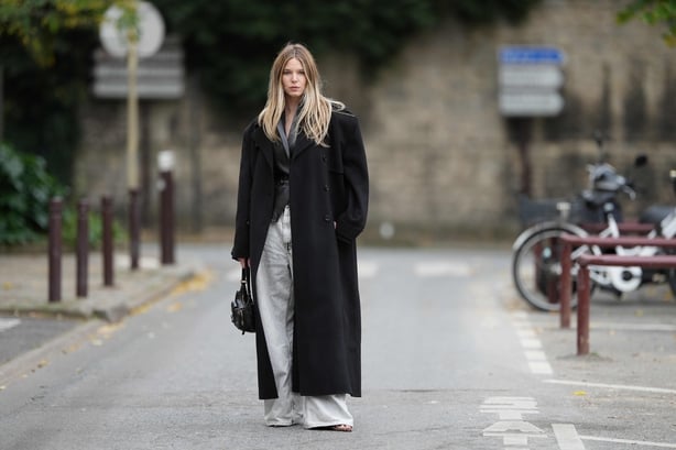 Natalia Verza wears a black wool long coat by The Frankie Shop