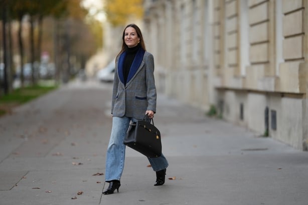 Alba Garavito Torre wears a black cashmere turtleneck sweater, a grey and blue wool straight-cut blazer