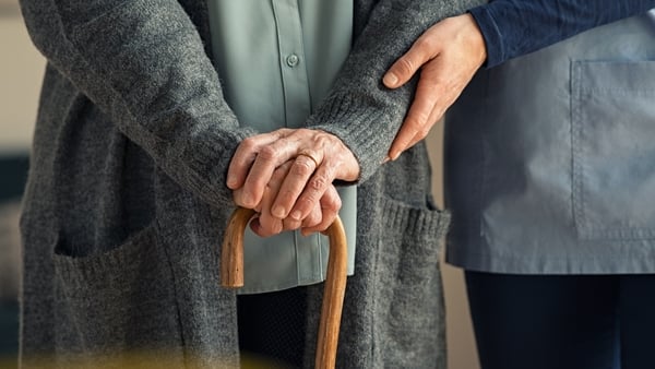 Close up hands of caregiver helping a woman