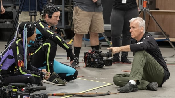 (L-R) Zoe Saldaña, Sam Worthington, and director James Cameron on the set of Avatar: Fire and Ash. Photo by Mark Fellman. © 2024 20th Century Studios. All Rights Reserved. 