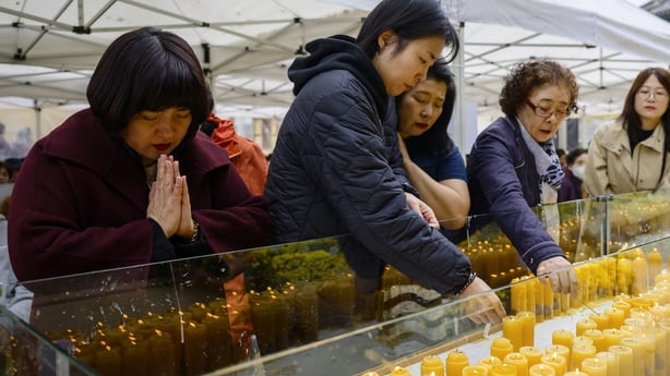People pray and light candles at the Jogyesa Buddhist temple