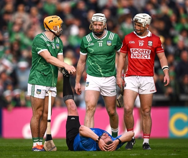 7 June 2025; Cian Lynch of Limerick and Tommy O'Connell of Cork look on as referee Thomas Walsh is attended to by Adam English of Limerick during the Munster GAA Hurling Senior Championship final match between Limerick and Cork at TUS Gaelic Grounds in Limerick. Photo by Ray McManus/Sportsfile