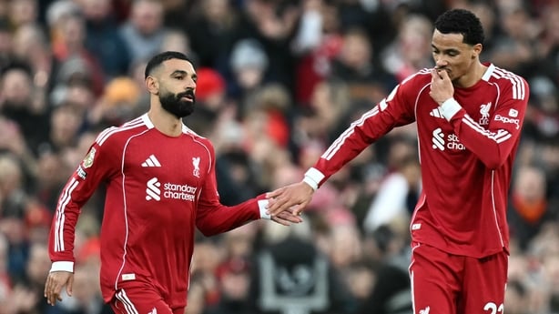 Liverpool's French striker #22 Hugo Ekitike (R) taps hands with Liverpool's Egyptian striker #11 Mohamed Salah as he comes off of the bench to play during the English Premier League football match between Liverpool and Brighton and Hove Albion at Anfield in Liverpool, north west England on December