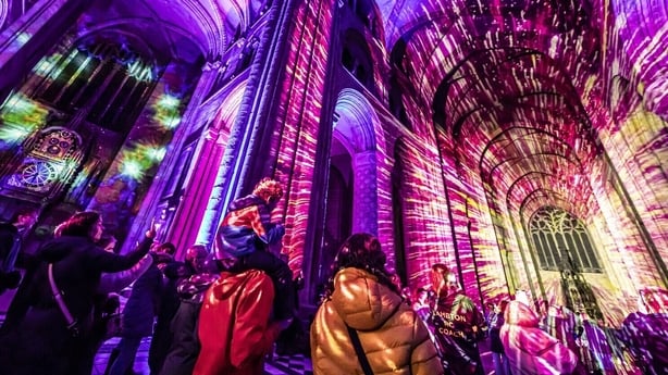 People watch as images are projected onto the interior of a building as part of the Starlight experience.