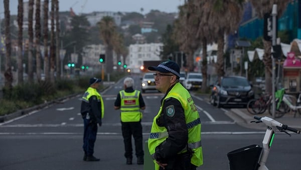 Police officers stand guard at a cordoned zone following the mass shooting at Bondi Beach in Sydney