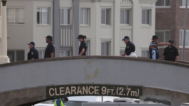 Police and forensic experts inspect at the scene of a shooting at Bondi Beach in Sydney 