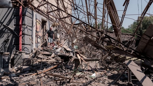 A person walks amongs damaged buildings after a missile attack in Ukraine