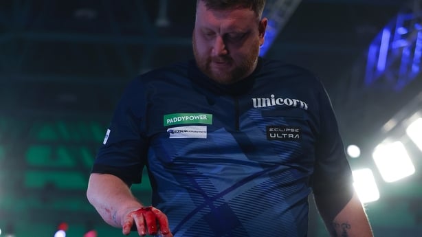 LONDON, ENGLAND - DECEMBER 15: Cameron Menzies of Scotland walks off the stage with a deep cut sustained on his right fist after punching the drinks stand in anger after losing to Charlie Manby of England during day five of the 2025/26 Paddy Power World Darts Championship at Alexandra Palace on Dece