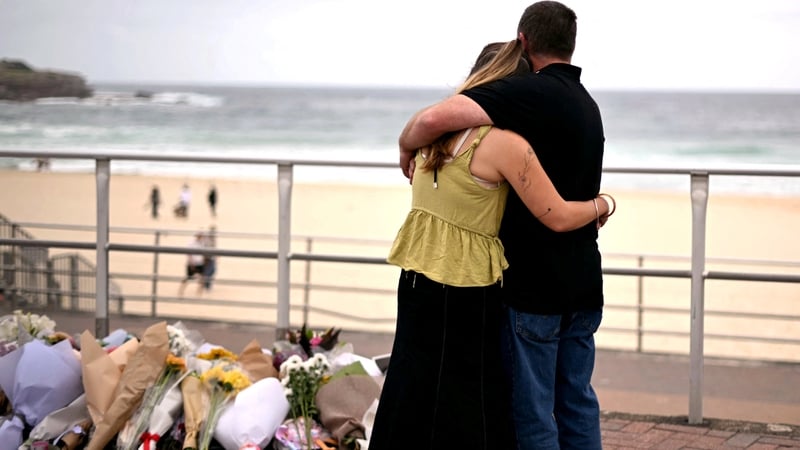Mourners gather by tributes in memory of the victims of the shooting at Bondi Beach