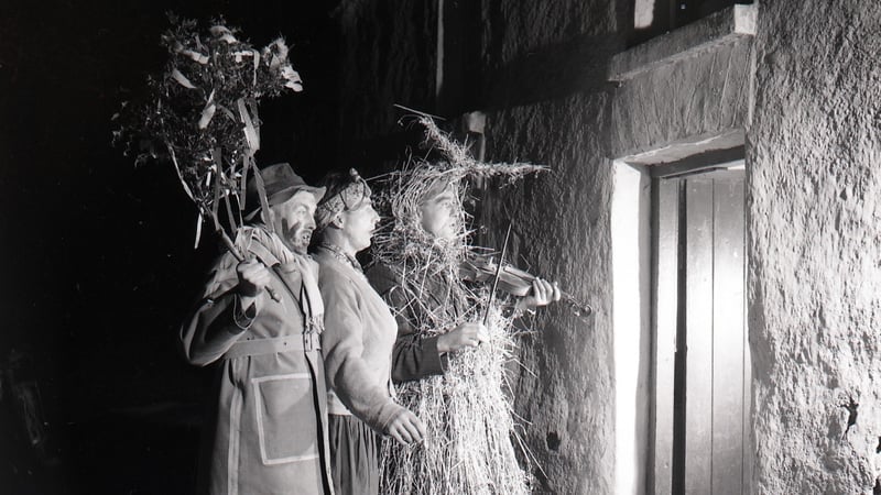 A strawboy and two wren boys outside the door at Lios Buí Kilnamartry, Macroom Co Cork, in 1952. Photo: George Pickow/University of Galway