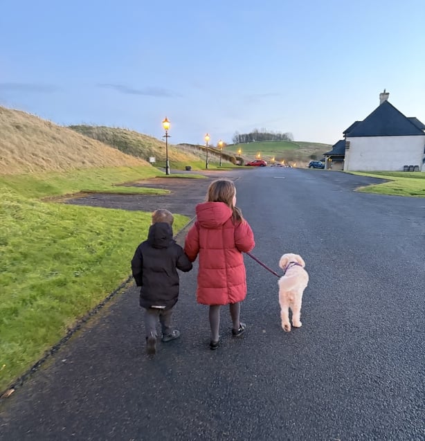 two children walking a dog