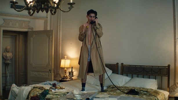 Timothée Chalamet standing on a bed in Marty Supreme