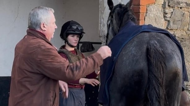 Eric McNamara hosing down a horse in the yard