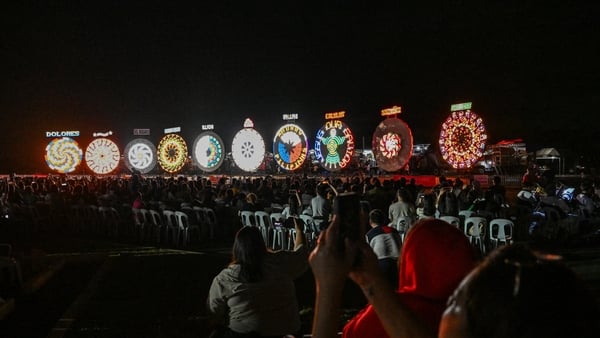 This photo taken on December 14, 2025, shows people watching during the Giant Lantern Festival in San Fernando, Pampanga. In Christmas-mad Philippines, thousands cheered as hand-crafted lanterns towering six metres (20 feet) high lit up the night sky in S