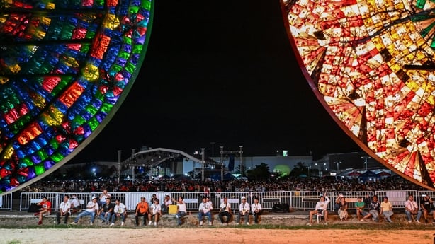 This photo taken on December 14, 2025, shows people watching during the Giant Lantern Festival in San Fernando, Pampanga. In Christmas-mad Philippines, thousands cheered as hand-crafted lanterns towering six metres (20 feet) high lit up the night sky in San Fernando, northwest of the country's capit
