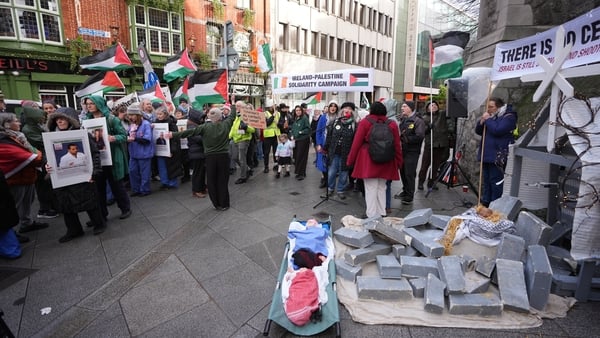 Irish Health Workers for Palestine pass the Gaza Solidarty Nativity Scene showing baby Jesus lying in rubble on Suffolk Street, Dublin