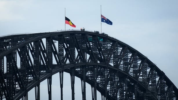 The Australian and Aboriginal flags fly at half mast on the Sydney Harbour Bridge