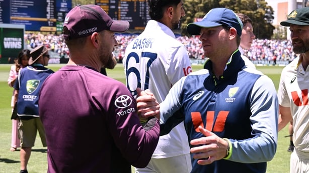 Australia's Steve Smith (R) shakes hands with England coach Brendon McCullum 