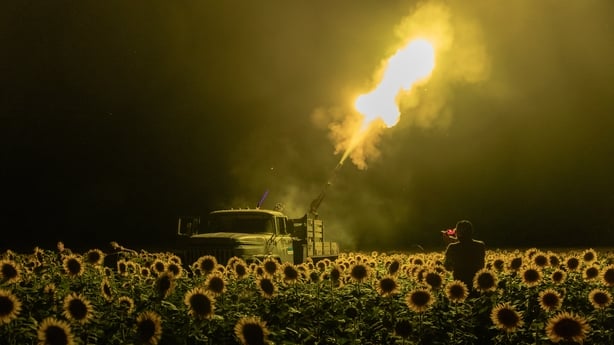 Ukrainian servicemen fire a Soviet made ZU-23 anti-aircraft twin autocannon towards a Russian drone from a sunflower field
