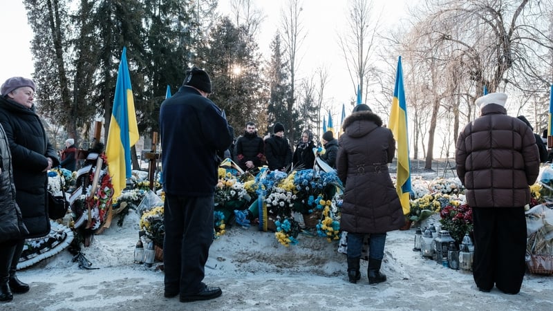 People attend a Christmas ceremony at a military cemetery in Lviv to remember Ukrainian soldiers who died during the war