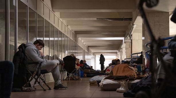 People sit with their belongings in a metro shelter in kyiv, ukraine