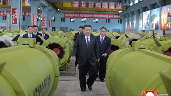 Photo shows Kim Jong Un with men in the background visiting major munitions industry enterprises