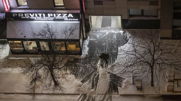 A person cleans the street as snow falls during a winter storm in New York City 