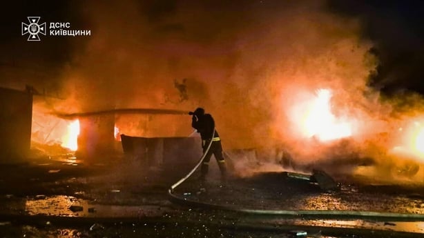 Firefighter crews work to extinguish flames following a Russian attack on Kyiv