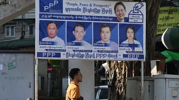 A man walks past signboards of the People's Pioneer Party (PPP) in Yangon