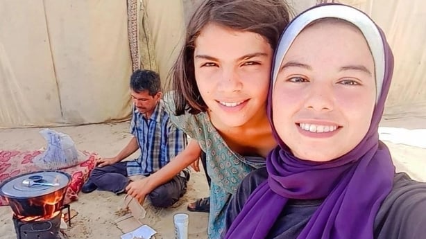 Ghada with on girl (Tasneem) and brother (Hamza) cooking in background