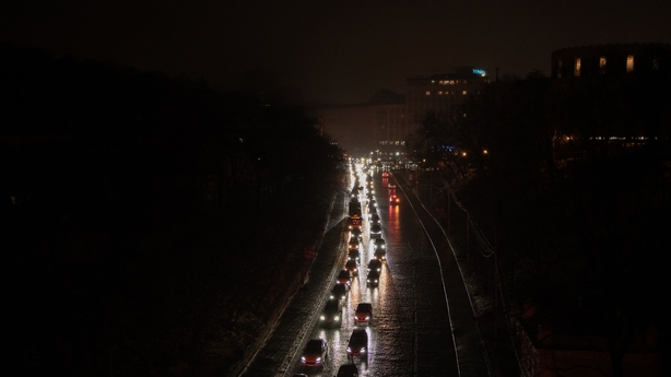This photograph shows vehicles with headlights driving down a non-illuminated road during a power outage in Kyiv on december 27, 2025, following Russian missile and drone attacks on Ukrainian energy infrastructure amid the Russian invasion of Ukraine. Russia pummelled Ukraine's capital with drones a