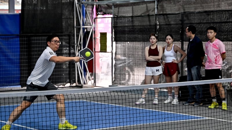 A man plays pickleball in the playground of a residential area in Hanoi