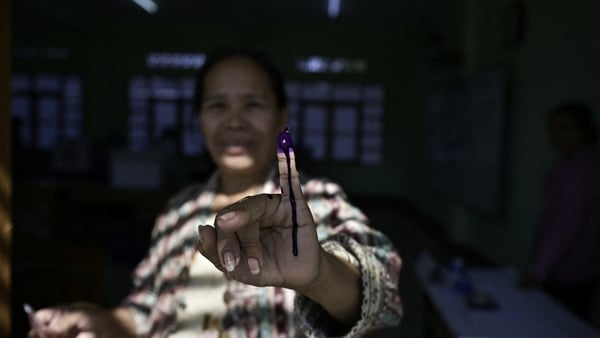 A woman shows her inked finger after casting her vote