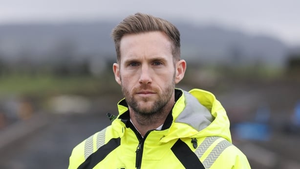 A photograph of James Fraser with a building site blurred in the background