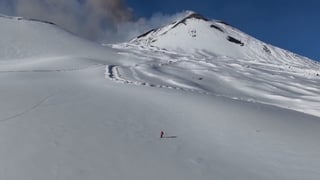 Skiers glide down slopes as Mount Etna erupts