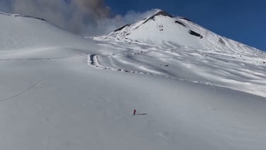 Skiers glide down slopes as Mount Etna erupts