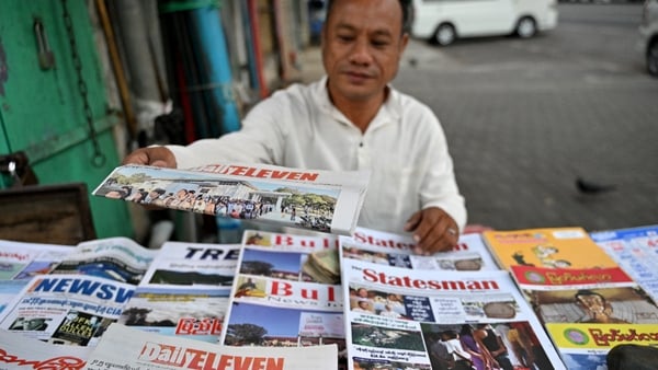 A vendor arranges newspapers reporting on Myanmar's general election in Yangon on December 29, 2025