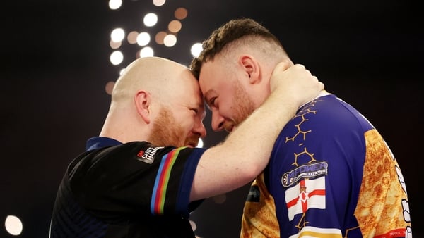 England's Justin Hood (left) celebrates winning his match against Northern Ireland's Josh Rock on day seventeen of the Paddy Power World Darts Championship at the Alexandra Palace