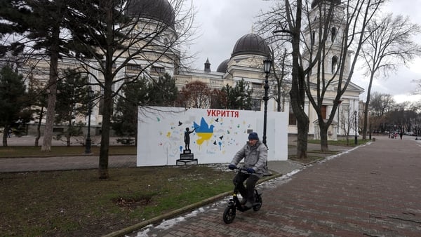 A man rides an electric bike with a church building in the background