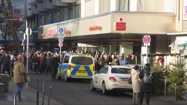 Photo shows people gathered outside bank where robbery occurred